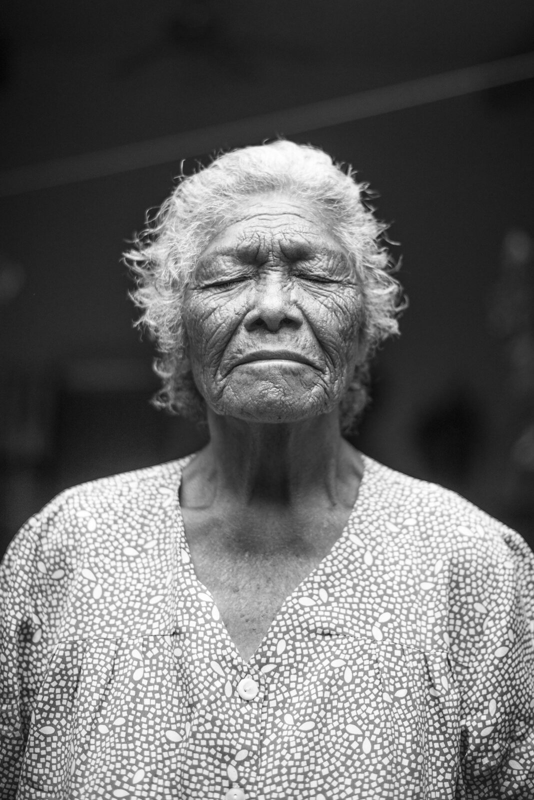 Black and white portrait of an elder woman with her eyes closed